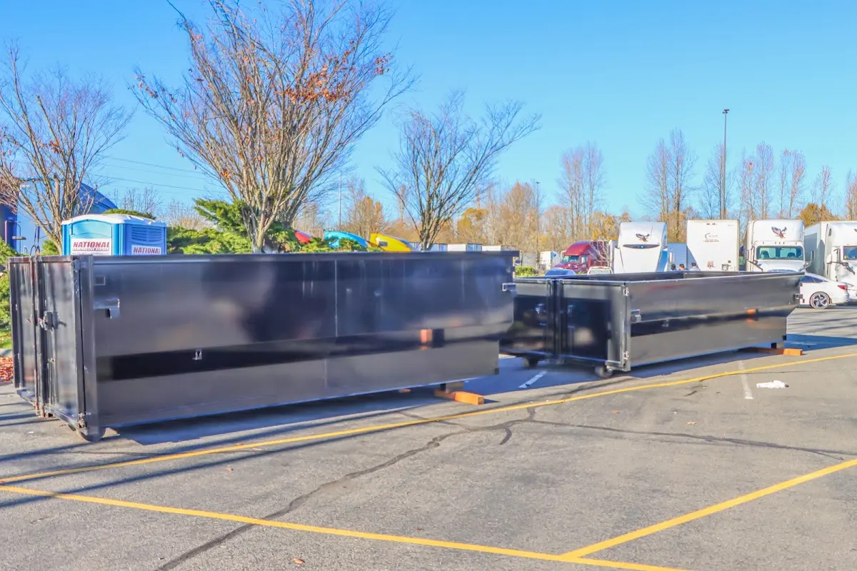 Professional dumpster rental service with roll-off container on residential driveway in American Falls